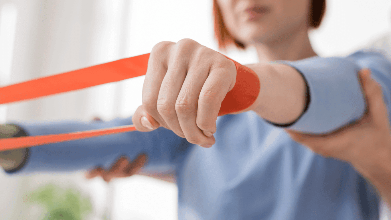 Kvinna som har tränar med gummiband runt båda handlederna.