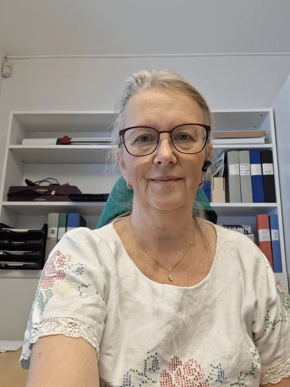 Person på kontor framför bokhylla med pärmar och dokument.